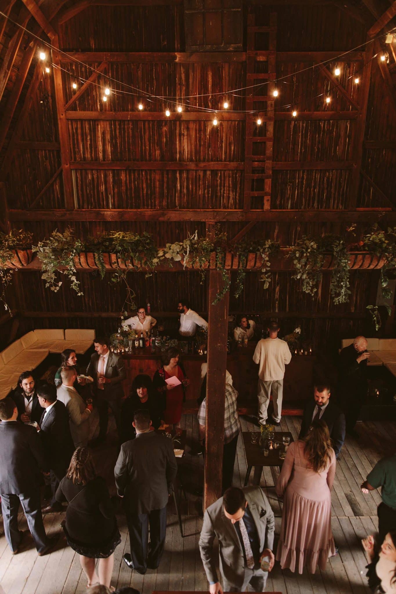 inside view of a wooden bar with lights hanging and wedding party